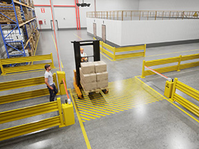 Pedestrian held at an AisleCop gate as a forklift carries boxes across a striped crossing in a shipping area
