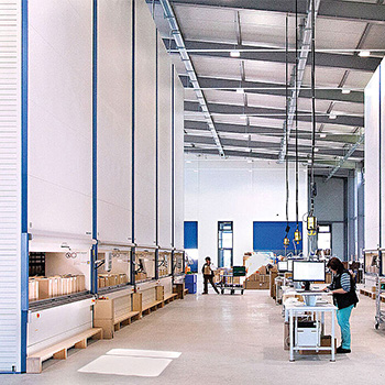 workers in an aisle between VLMs