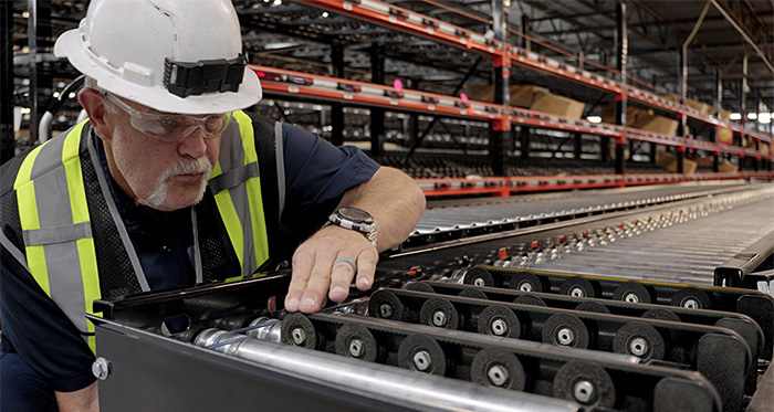 technician in hard hat inspecting O-rings on conveyor