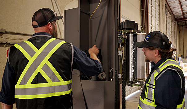 Cisco-Eagle technicians working on a pallet stretch wrapper