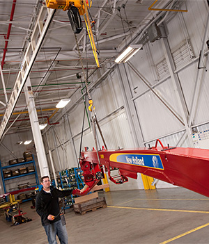 worker using crane and hoist to lift a large component